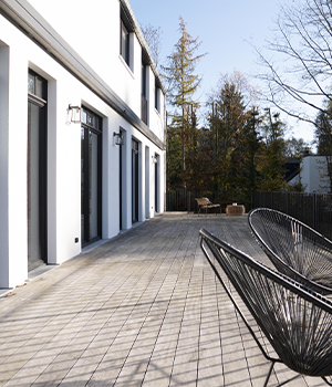 Terrasse centrale protégée dans une maison contemporaine en L 