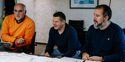 Équipe Piron Construction en pleine collaboration, partageant plans et idées architecturales