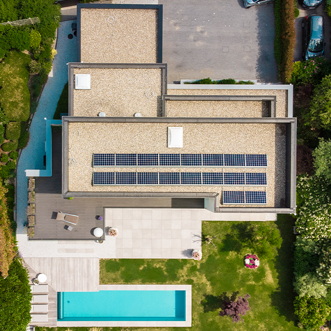 Maison en L contemporaine avec toit plat, grandes baies vitrées et jardin paysager