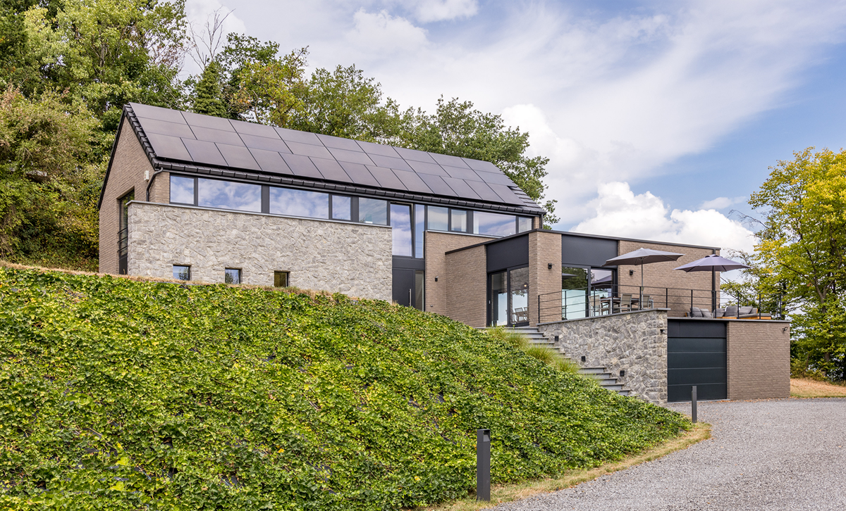 Maison moderne en L avec terrasse exposée sud, garage et grandes ouvertures